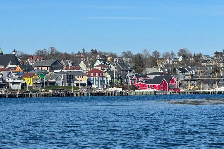En pittoresk stad vid vattnet med färgglada hus, en brygga och en klarblå himmel. 4
