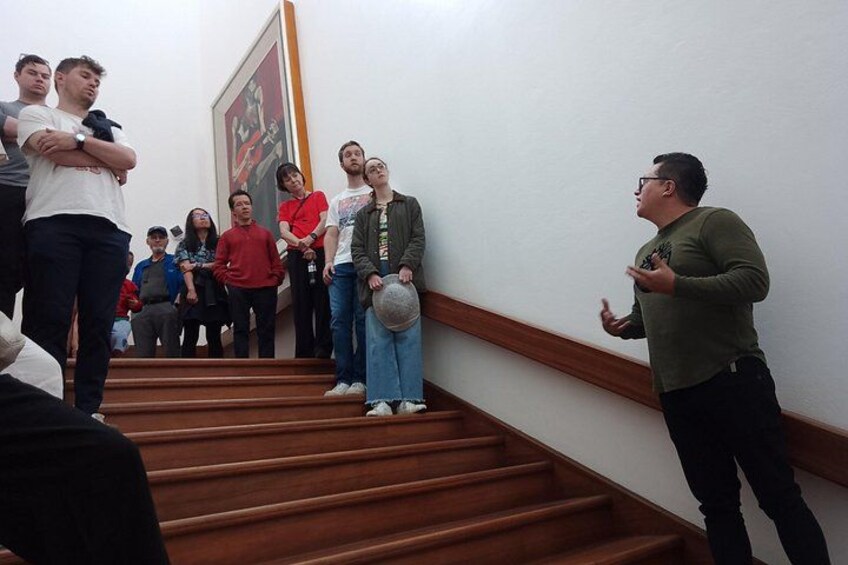 Un grupo de personas en una escalera, algunas mirando hacia arriba a alguien que habla. 3