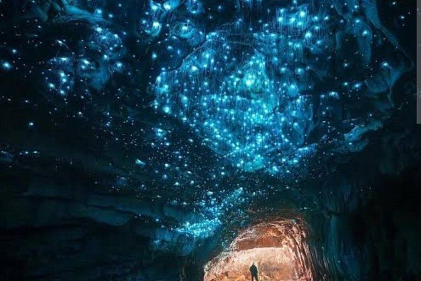 Eine Höhle mit einer Person am Eingang, umgeben von einem Sternenhimmel. 5