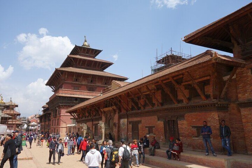 A traditional multi-tiered building with a crowd of people in front. 5