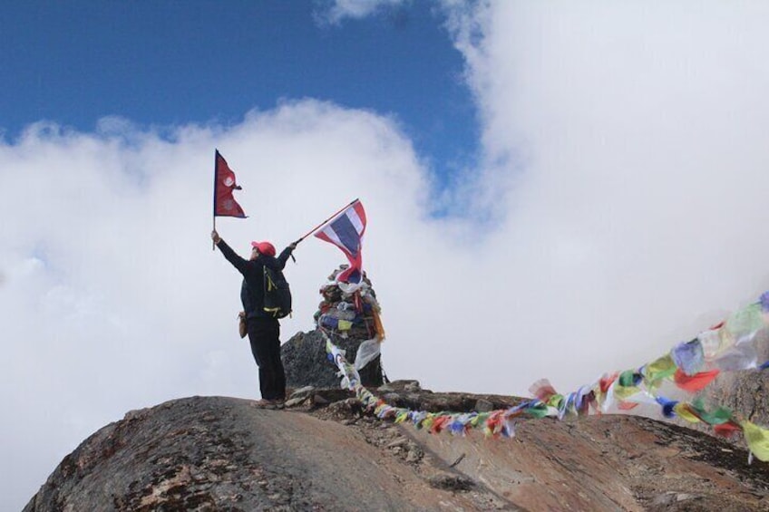 Two people on a mountain peak, one holding a flag. 2