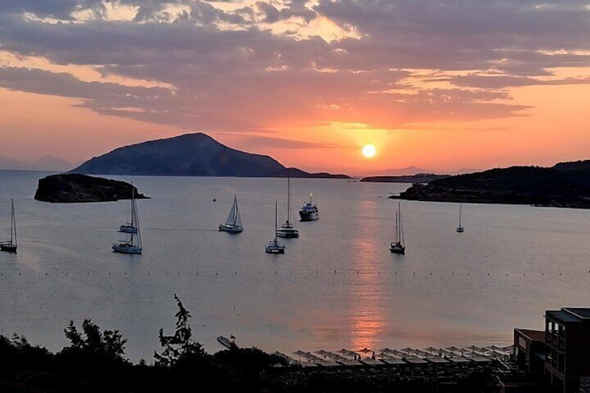 Solnedgang over et roligt hav med flere sejlbåde i anker. 3
