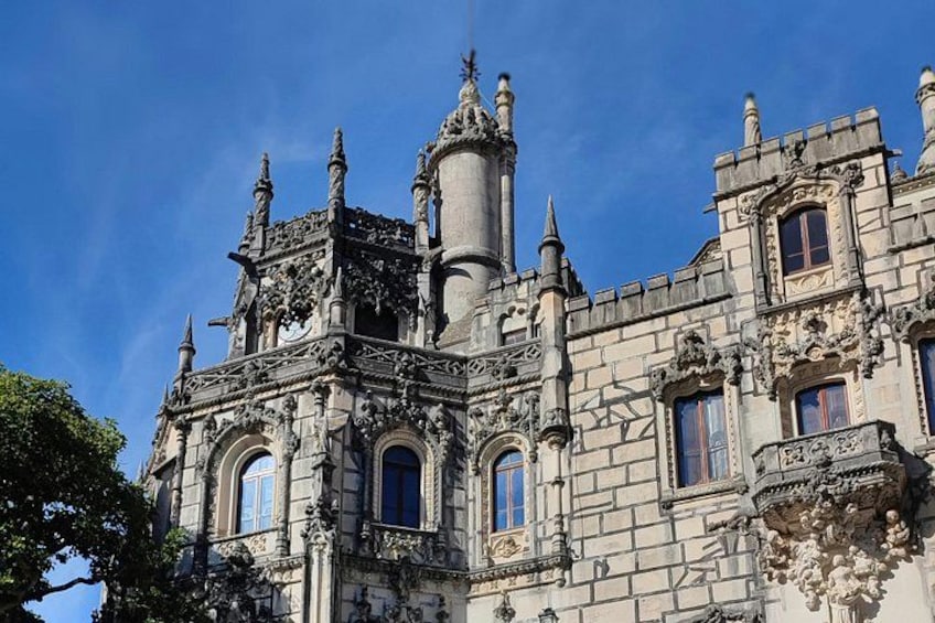 A historic building with ornate architecture, including a tower, arched windows, and decorative stonework. 2