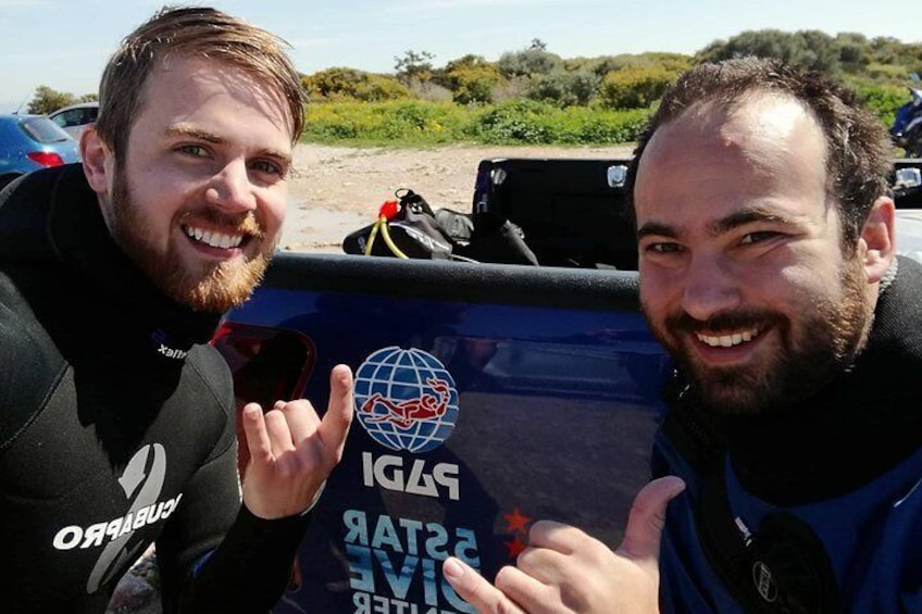 Two people in wetsuits sitting in a vehicle with a logo that includes a globe and the text "STARET". 1