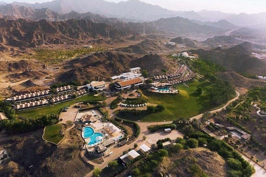 A resort with multiple buildings, a swimming pool, and a mountainous landscape. 3