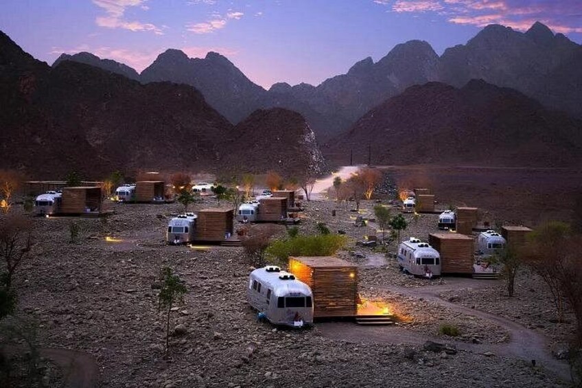 A campground with RVs and cabins in a mountainous area. 2