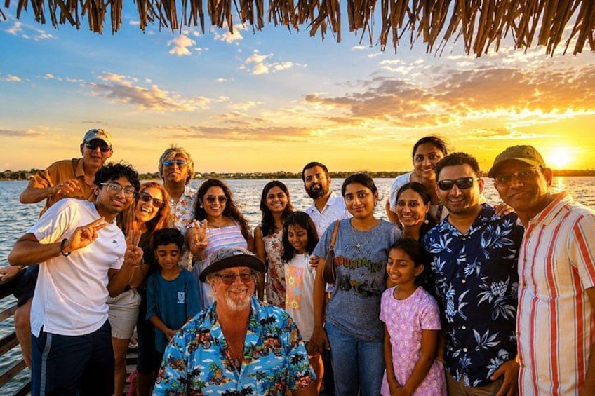 Een groep mensen op een boot tijdens de zonsondergang. 3