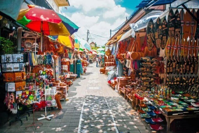 Een levendige marktstraat met kleurrijke parasols en diverse kraampjes die souvenirs en handwerk verkopen. 4