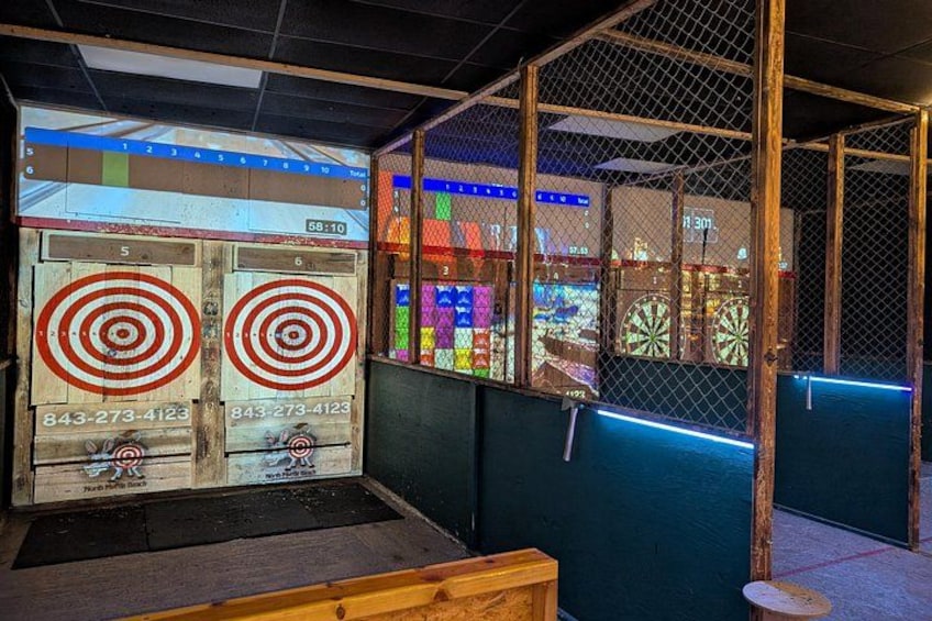 A bowling alley with pinsetters and a dartboard. 1