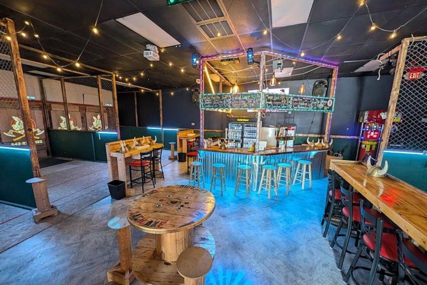 Un bar con taburetes, una barra y luces de neón. 3