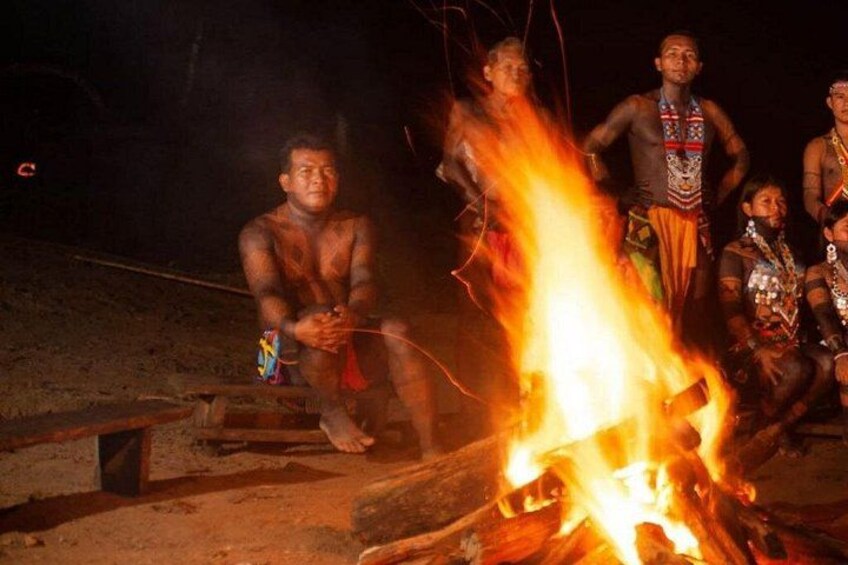 A group of people around a campfire at night. 1