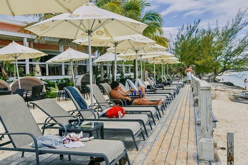 Un salon de plage équipé de chaises longues et de parasols. 2