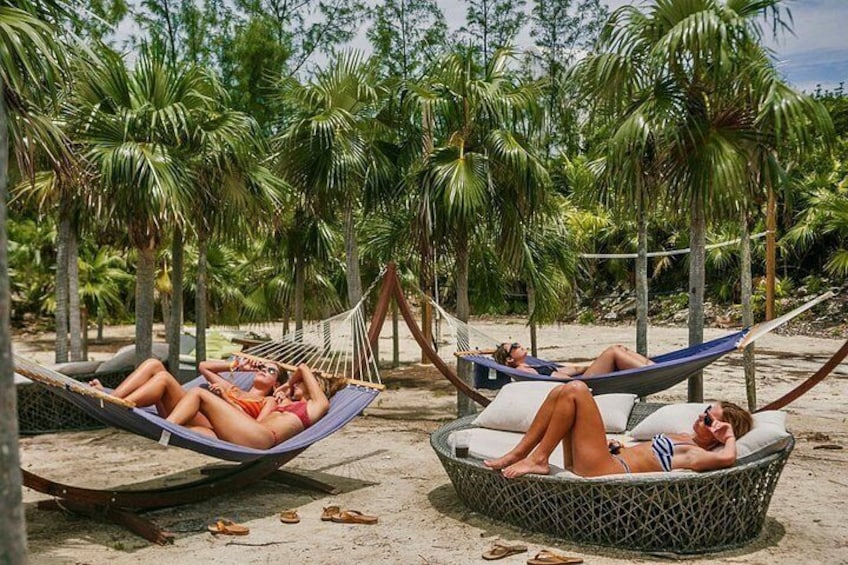 Trois hamacs sur une plage de sable, avec des palmiers en arrière-plan. 3