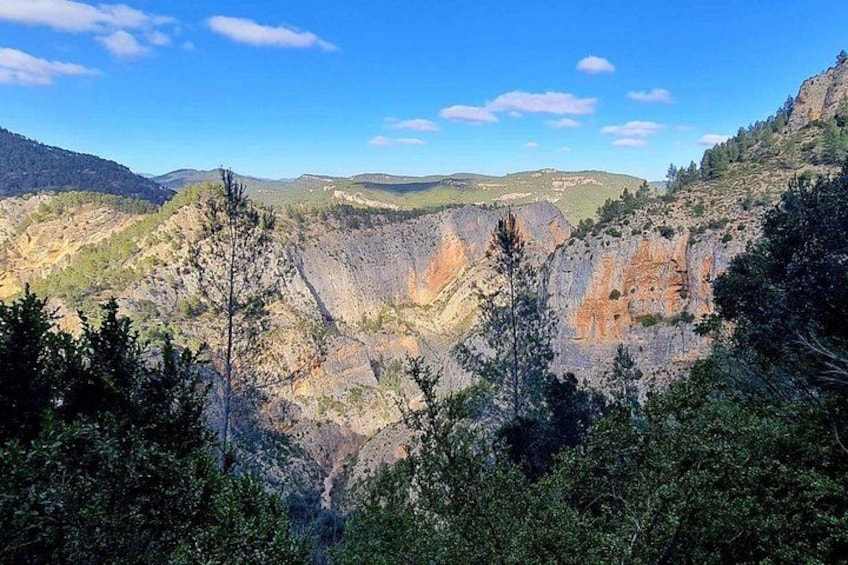 A canyon with steep cliffs and sparse vegetation. 5