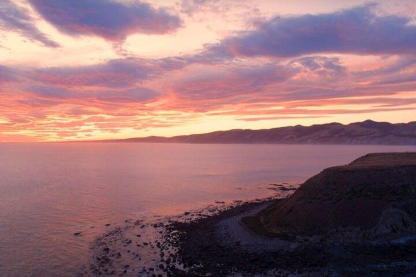 Un paisaje costero con atardecer, acantilados y un mar tranquilo. 1
