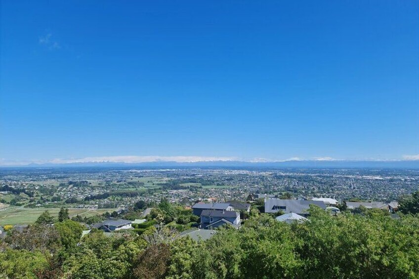 A panoramic view of a town with houses, trees, and a clear blue sky. 2