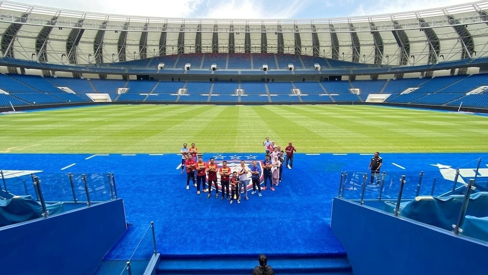 A stadium with blue seats and a group of people on a blue carpet. 2