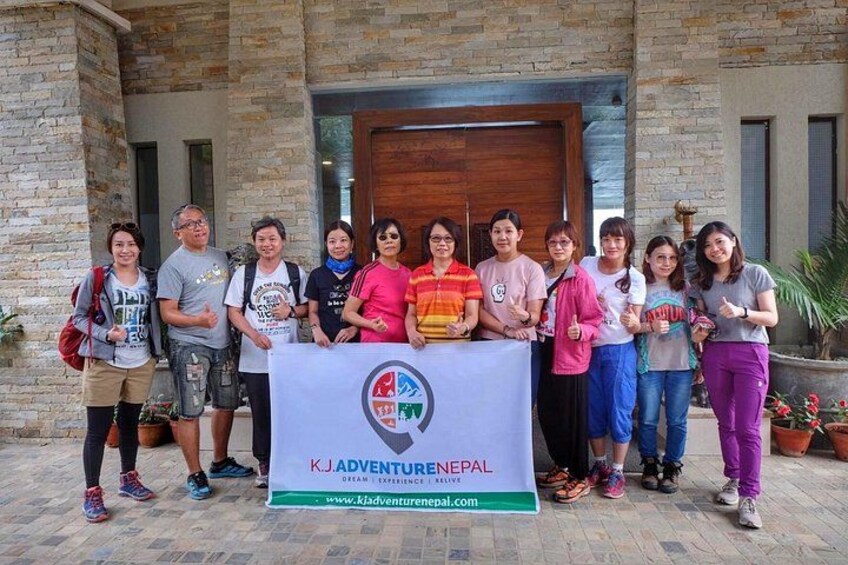 A group of people standing in front of a building with a banner that reads 'K.J. Adventure Nepal.' 3