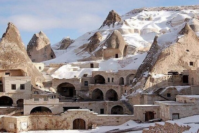 A snow-covered village with unique conical rock formations and traditional architecture. 2