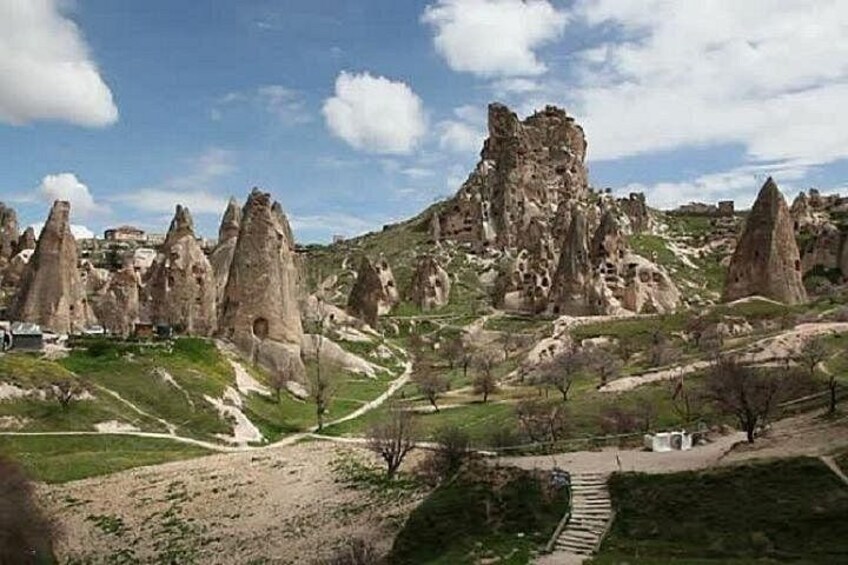 A landscape with unique rock formations, a clear sky, and a pathway. 4