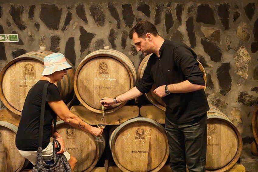 Une personne qui verse du vin d’un tonneau dans un verre. 4