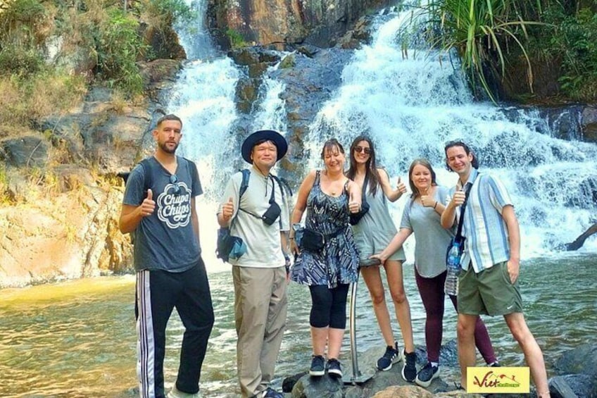 A group of people standing in front of a waterfall. 3