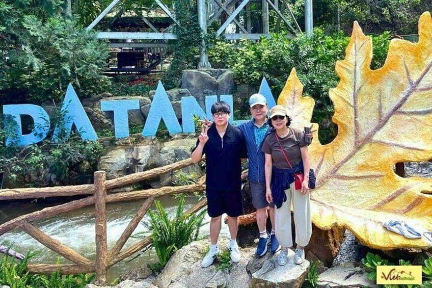 A sign with the word 'DATAN' and a large leaf sculpture. 2