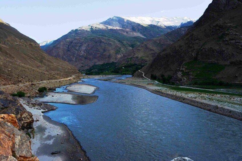 A river winding through a mountainous landscape with snow-capped peaks in the background. 2