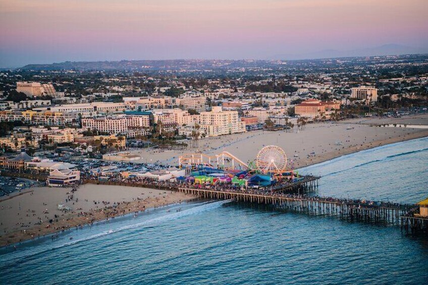 A beach with a pier, a Ferris wheel, and a boardwalk. 5