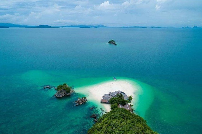 A tropical island with clear turquoise waters, a white sandy beach, and lush greenery. 1