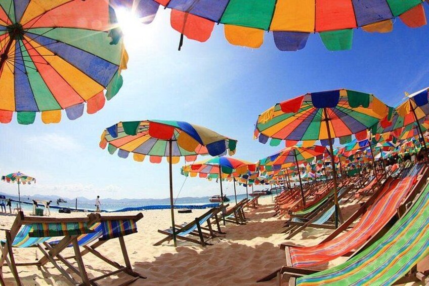 Une plage avec des parasols et des chaises de plage aux couleurs vives et à rayures. 2
