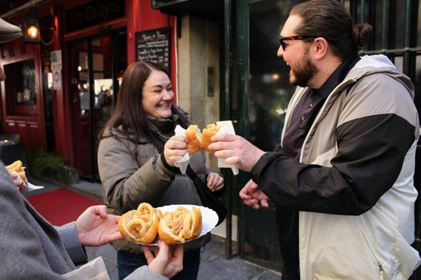 Personas sosteniendo alimentos frente a un edificio. 1