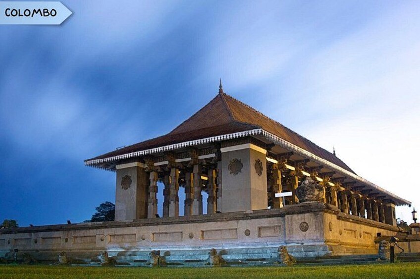 A large, historic building with a prominent dome and columns, surrounded by a well-maintained lawn. 3