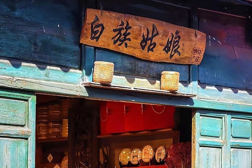 Une devanture de magasin avec une enseigne en bois, des paniers et une présentation d’objets ronds. 2