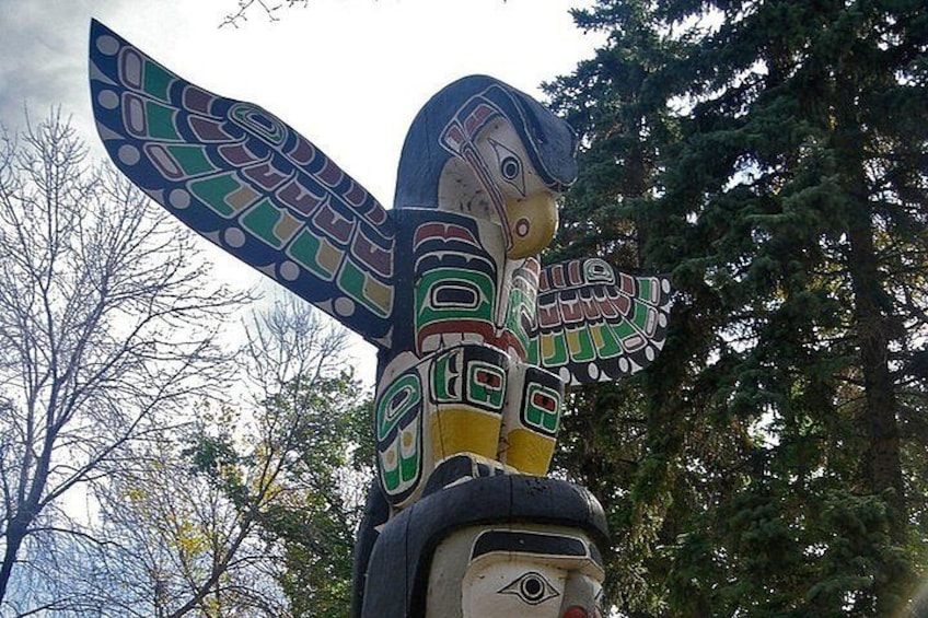 A totem pole with intricate designs and a bird figure. 5