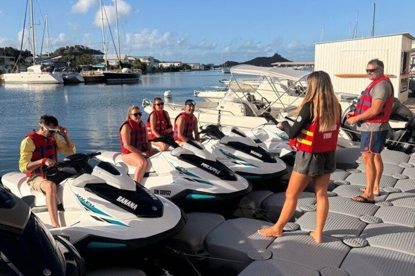 People on jet skis at a marina with boats in the background. 2