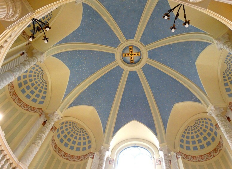 A domed ceiling with a cross at the center, star patterns, and ornate columns. 2