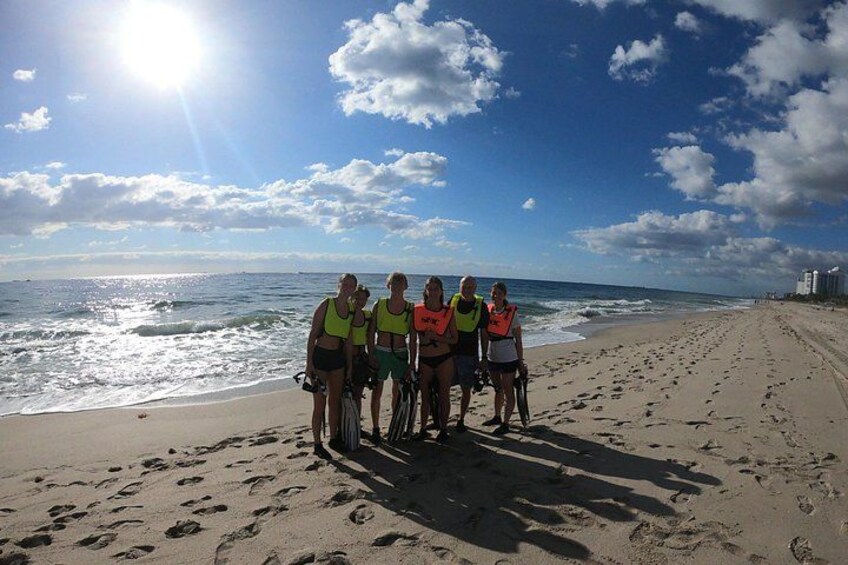 A group of people on a beach with the ocean in the background. 2