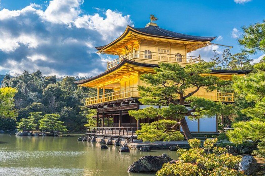 A traditional Japanese pagoda with a golden roof, surrounded by lush greenery and a calm lake. 3