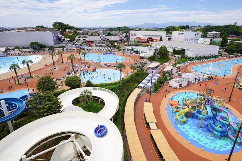 Een waterpark met meerdere zwembaden, glijbanen en een groot golfzwembad. 1