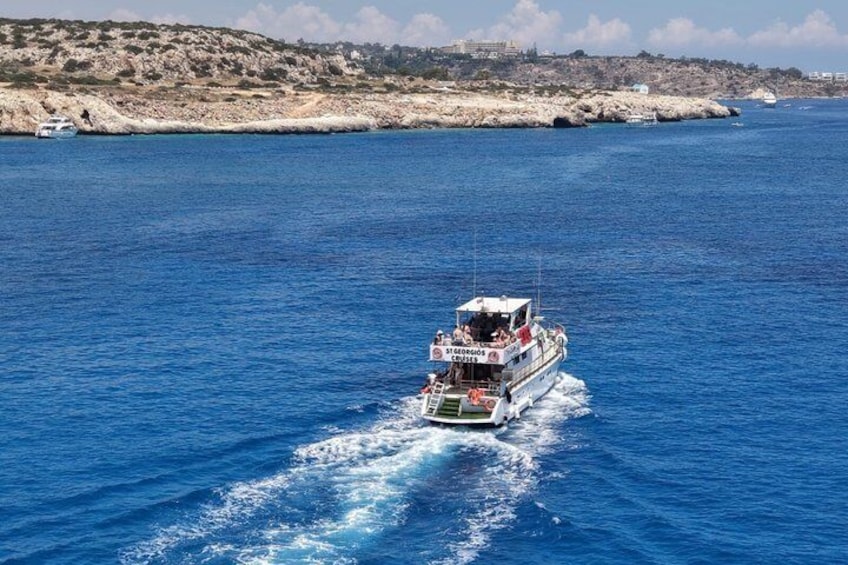 Un barco con la inscripción 'St. Marinus' navegando sobre un mar azul, con una costa rocosa al fondo. 4