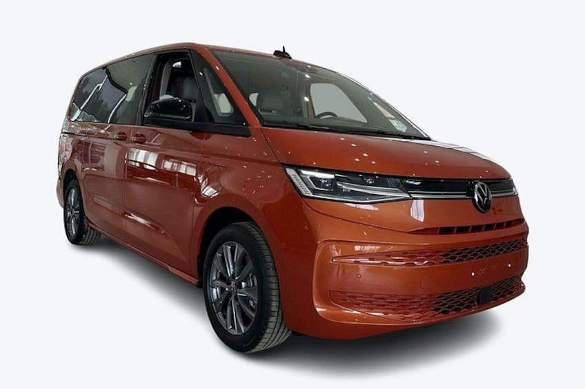 A red Volkswagen minivan with a sleek design, chrome grille, and modern headlights. 2
