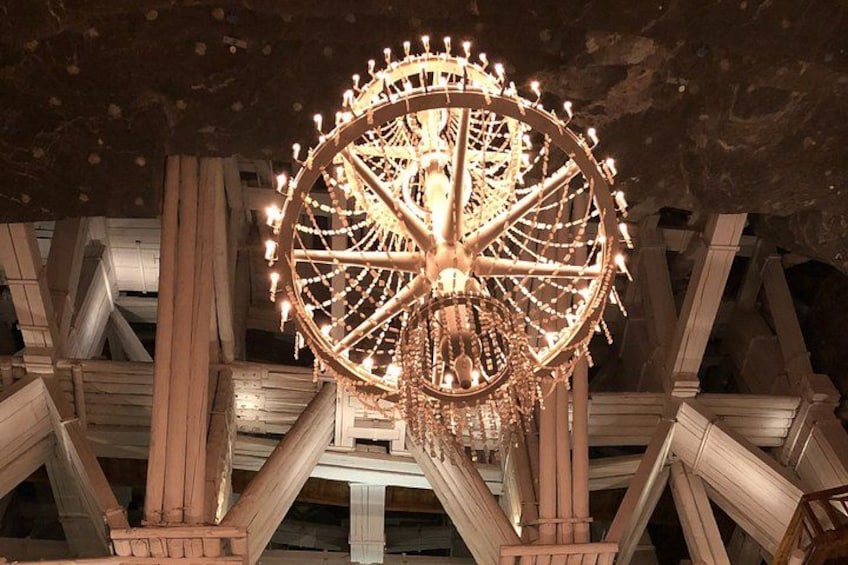 A large Ferris wheel with lights, set against a wooden structure. 3
