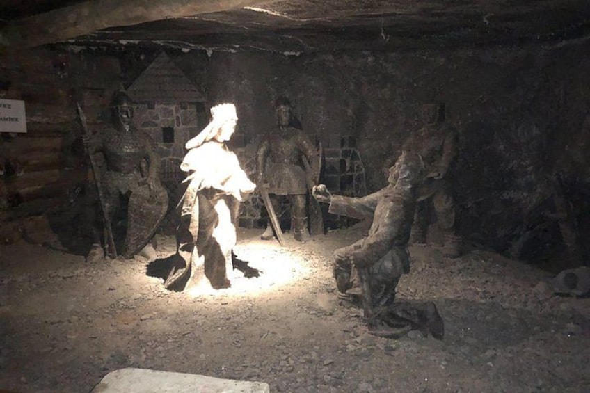 A cave with stone statues and a person in white. 3