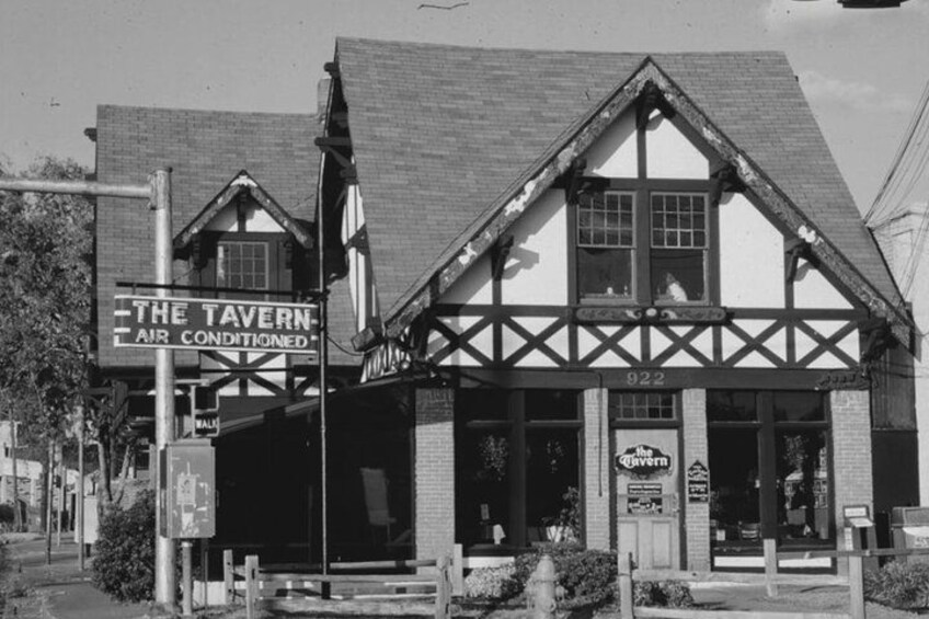 Et sort-hvidt billede af en toetagers bygning med et skilt, der siger "The Tavern Air Conditioned". 3