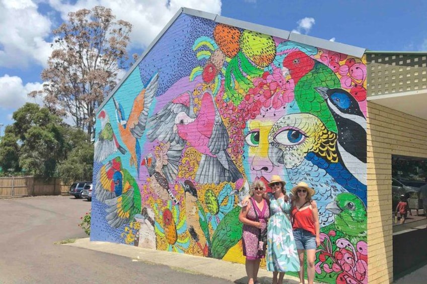 A colorful mural on a building with birds and floral patterns. 5