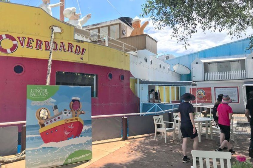 A colorful ship-themed restaurant named 'Overboard!' with a gingerbread house sign and outdoor seating. 2