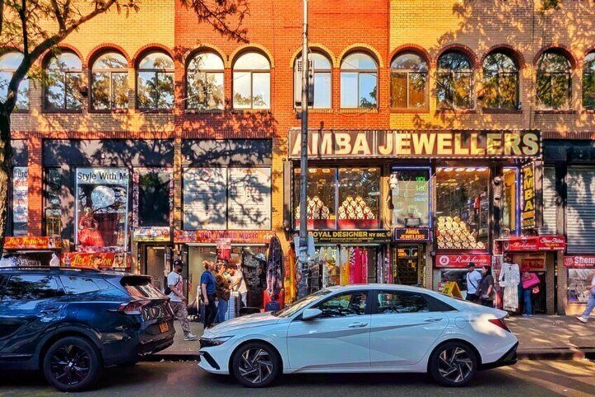 Une rue où se trouve une bijouterie appelée « Mba Jewellers » et une voiture blanche garée sur le bord. 4