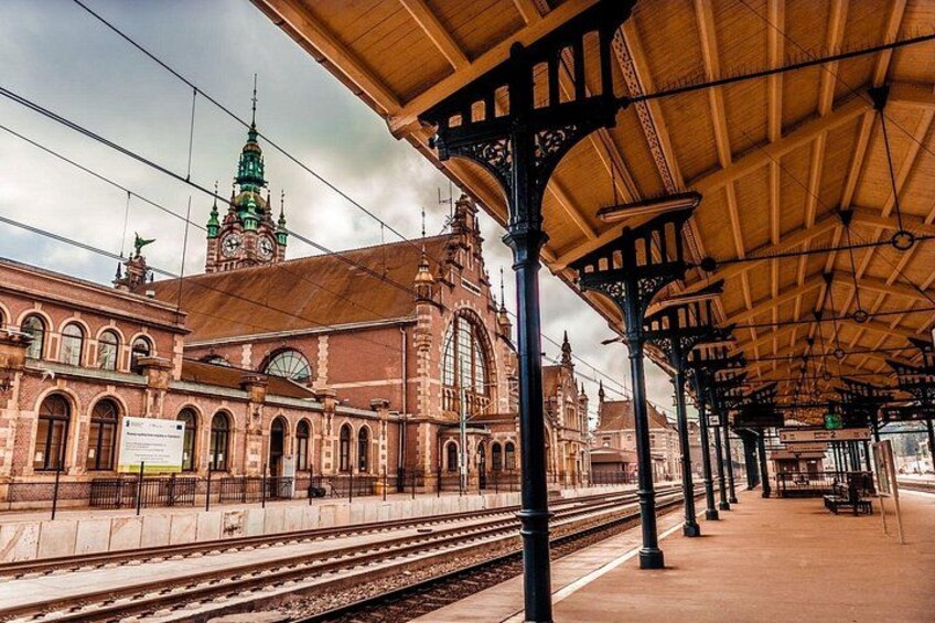 Una storica stazione ferroviaria con pensilina coperta, diverse banchine e un'imponente torre dell'orologio. 1