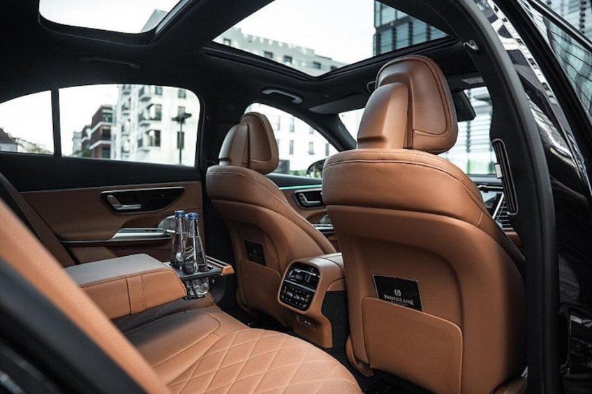 A car interior with tan leather seats and a sunroof. 2